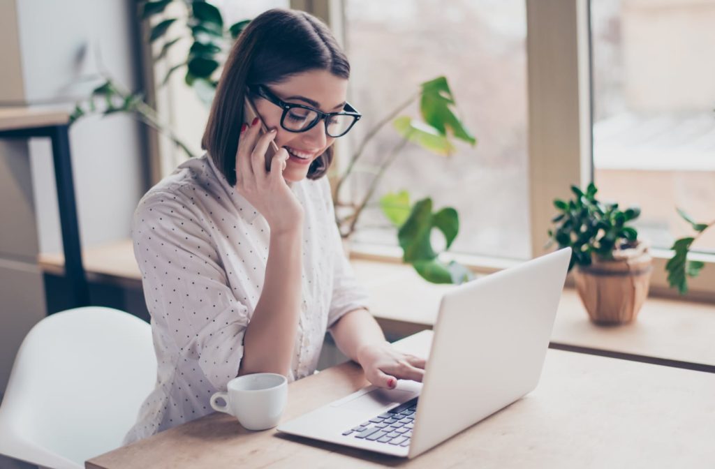 Young woman working at her computer with anti-fatigue lenses in her glasses