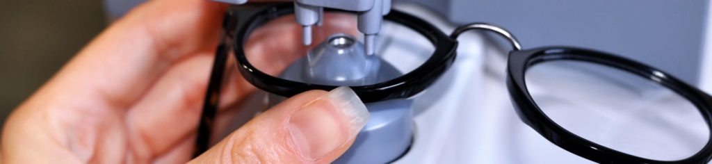 An optician preparing to fit lenses into eyewear frames