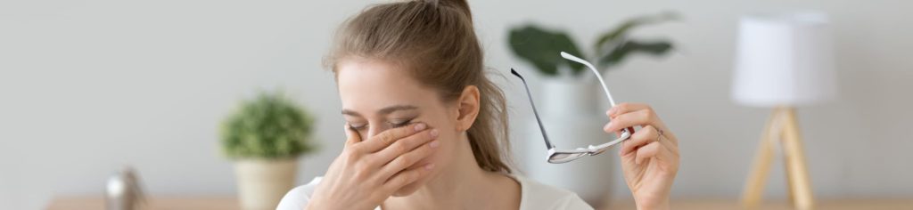 woman rubbing her dry eyes caused by dry air