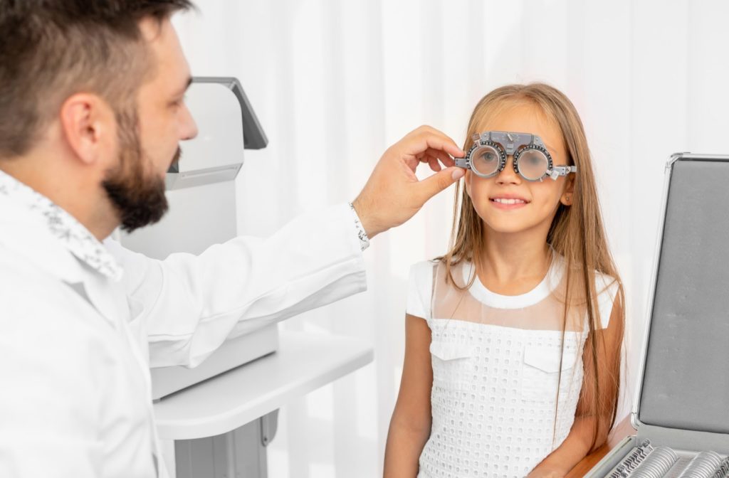 Young girl undergoing eye exam by her optometrist