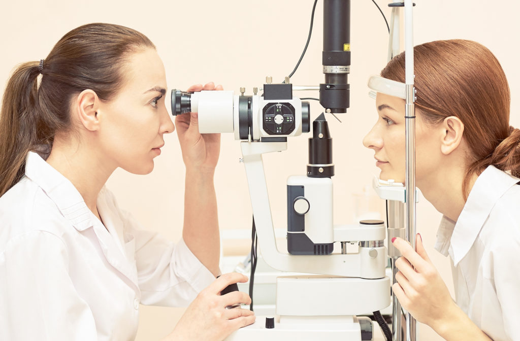 Women undergoing eye exam by her optometrist at office