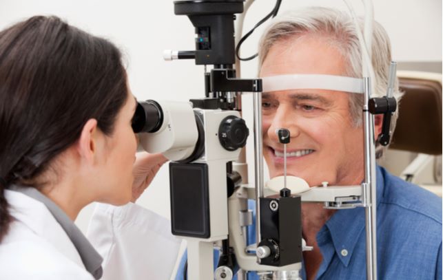 older gentlemen undergoing eye exam by optometrist to look for signs of diabetes