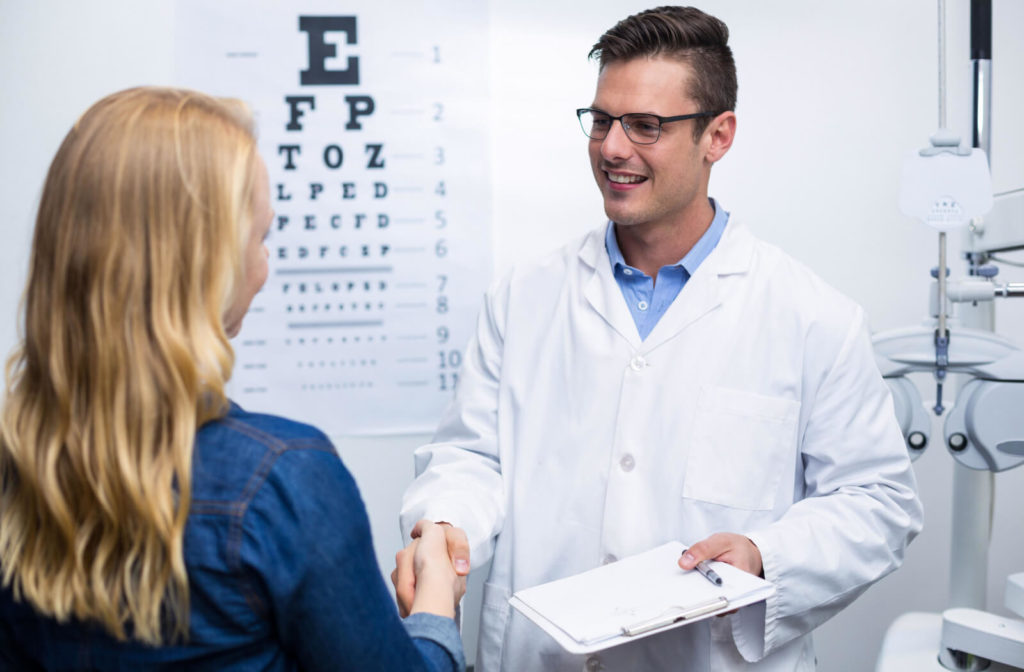 A woman in an optometry clinic shaking hands with a  male optometrist