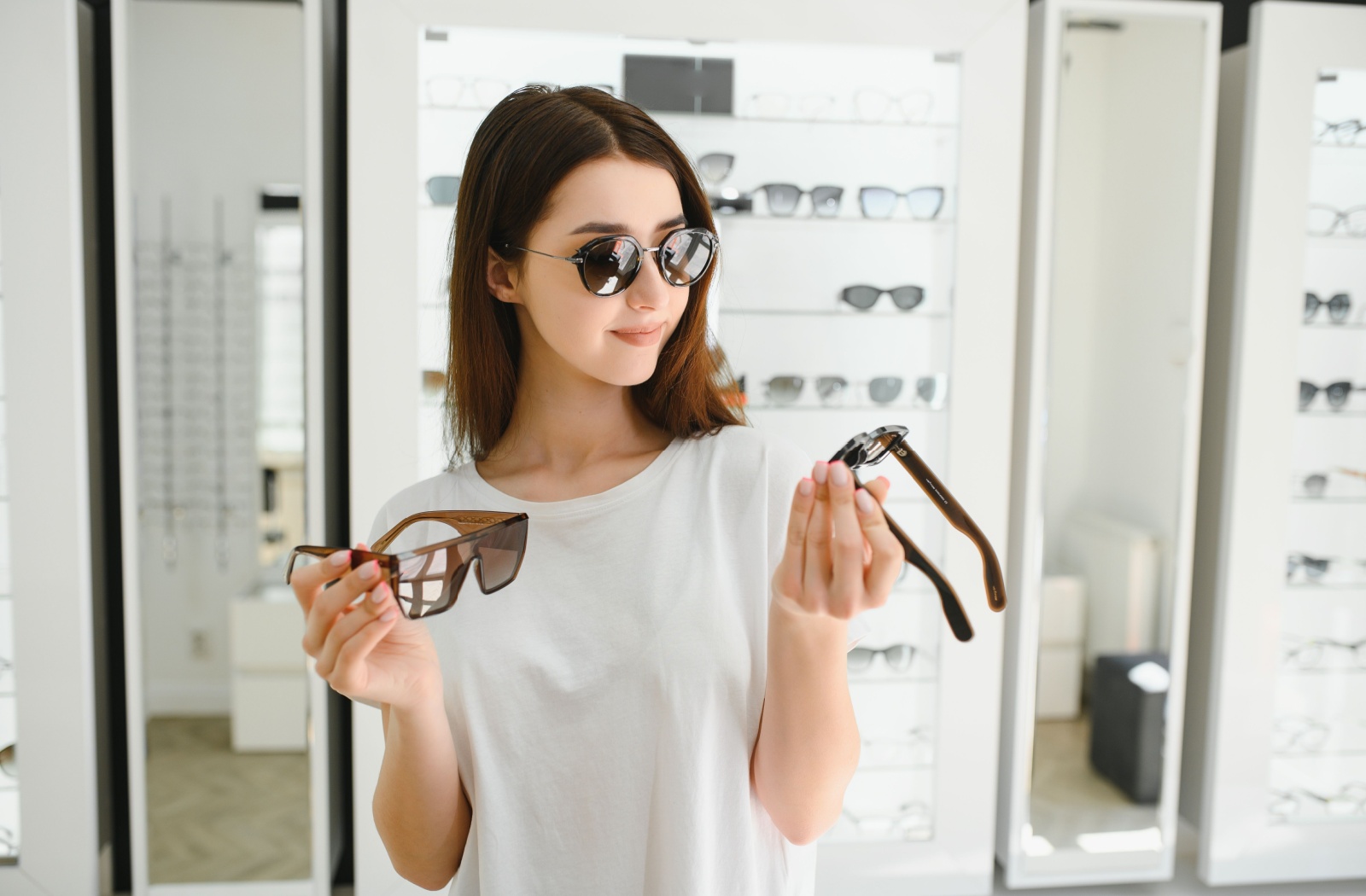A young person browsing and trying on new sunglasses at their local optometry clinic.